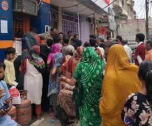 गैस बुकिंग कराकर लाइन में खड़े गैस उपभोक्ता