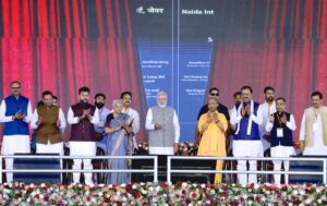 नोएडा इंटरनेशनल एयरपोर्ट उद्घाटन समारोह में मोबाइल फ्लैशलाइट जलाते लोग