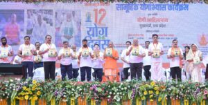झांसी में अंतरराष्ट्रीय योग दिवस कार्यक्रम के दौरान योगाभ्यास करते लोग और संबोधित करते मुख्यमंत्री योगी आदित्यनाथ