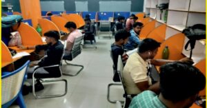 उत्तर प्रदेश के एक गांव में आधुनिक डिजिटल लाइब्रेरी में कंप्यूटर और पुस्तकों के साथ पढ़ाई करते छात्र।